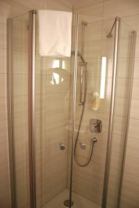 baño con ducha y puerta de cristal en Hotel Petzengarten en Núremberg