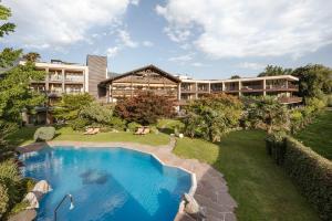 un complejo con piscina frente a un edificio en Hotel Wiesenhof, en Lagundo