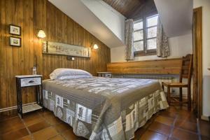 San Marsial Benasque Apart Hotel في بيناسكي: غرفة نوم بسرير في غرفة بجدران خشبية