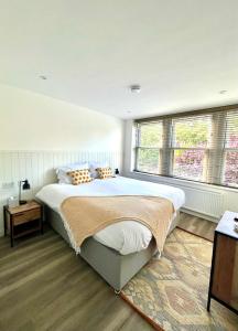 a bedroom with a large bed and two windows at Mode Apartments St Annes in Lytham St Annes