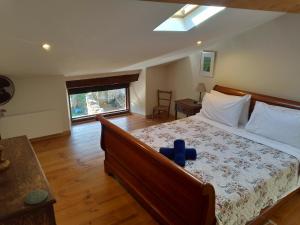 a bedroom with a bed with a blue teddy bear on it at L'Oustal des amis in Belcaire