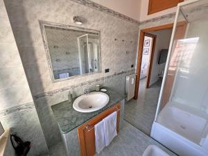 y baño con lavabo y espejo. en Domus Arianna, en Castellammare di Stabia