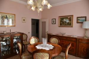 uma sala de jantar com uma mesa e cadeiras e um lustre em My House em Loreto