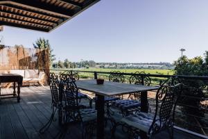 une table et des chaises sur une terrasse avec vue sur un champ dans l'établissement Al' Casas do Sal, à Alcácer do Sal