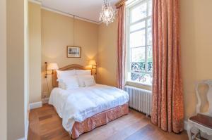 Schlafzimmer mit einem Bett und einem Fenster in der Unterkunft De Heerlijkheid Loenen Bed en Breakfast in Slijk-Ewijk