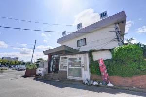 a gas station with two cats sitting outside of it at Hotel Sankyu in Tsukuba