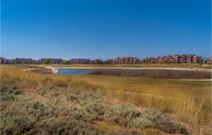 a lake in a field with buildings in the background at Lovely Apartment In Torre Pacheco in Torre-Pacheco