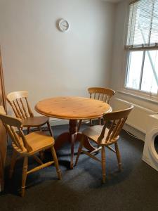 una mesa de madera y sillas en una habitación en Cozy 3 Bedrooms Home off Mill Road Sleep up to 6, en Cambridge