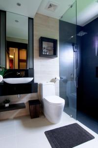 a bathroom with a toilet and a sink and a shower at Boracay Suites in Boracay