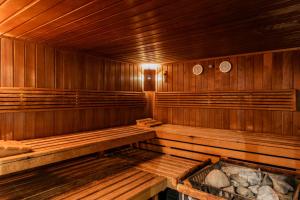 a wooden sauna with wooden benches in a room at Grand Hotel Opduin in De Koog