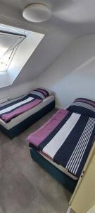 two beds in a room with a ceiling at Bruno's Ferienwohnung in Wendlingen am Neckar