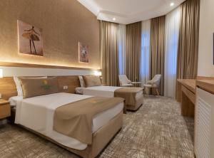 a hotel room with two beds and a desk at Merida Hotel Baku in Baku