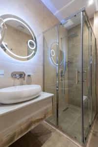 a bathroom with a glass shower and a sink at Merida Hotel Baku in Baku