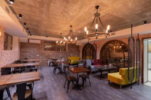 a restaurant with tables and chairs and a brick wall at Merida Hotel Baku in Baku