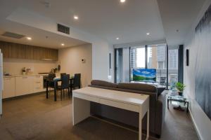 Il comprend un salon et une cuisine avec un canapé et une table. dans l'établissement Luxury 2 Bedroom Apartment - Adelaide CBD, à Adélaïde