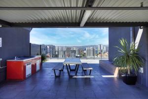 un patio avec une table et des bancs dans un bâtiment dans l'établissement Luxury 2 Bedroom Apartment - Adelaide CBD, à Adélaïde