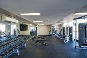 um ginásio com muitas passadeiras e máquinas em Luxury 2 Bedroom Apartment - Adelaide CBD em Adelaide