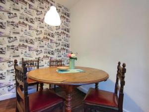 una mesa de comedor con sillas y un jarrón de flores en Number 22 - Le Dorat - Apartment 3, en Le Dorat