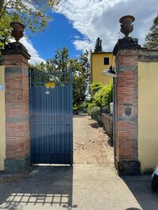 um portão azul numa parede de tijolos com uma entrada em la limonaia em Florença