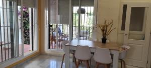 Un comedor con una mesa y sillas blancas. en Costa Ballena!!! House on Mediterranean Coast with pool and golf!!! Dúplex!!!, en Costa Ballena
