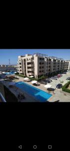 a large apartment complex with a swimming pool and buildings at صيف في جراند هيلز الساحل الشمالي in Al Ḩammām