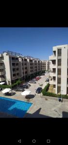 un gran complejo de apartamentos con piscina y edificios en صيف في جراند هيلز الساحل الشمالي en Al Ḩammām