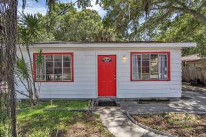 a small white house with a red door at Downtown Single Family Modern Bungalow close to beaches and dining home in Sarasota
