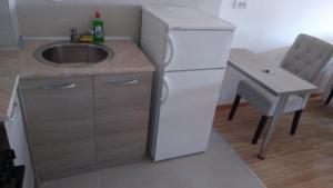 eine kleine Küche mit einem Waschbecken und einem Tisch in der Unterkunft Exceptional Suite in Čačak
