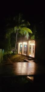 a palm tree in front of a building at night at Weekend Villa at Nature's Lap (Malshej Ghat) in Ghātghar