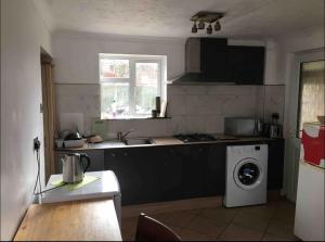 a kitchen with a sink and a washing machine at Nikolay’s House in Bristol