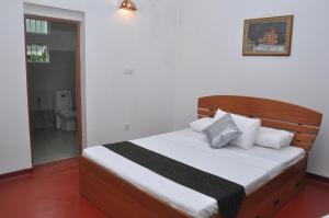 1 dormitorio con 1 cama con cabecero de madera en Kurumba Hills, en Bentota