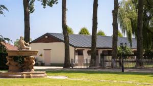 une fontaine dans l'herbe devant une maison dans l'établissement Het Spechtennest, à Zedelgem