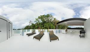 eine Terrasse mit Stühlen und Tischen auf einem Gebäude in der Unterkunft Boracay Suites in Boracay