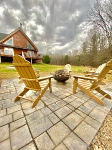 - 2 chaises et une table de pique-nique sur la terrasse dans l'établissement Spacious luxurious log cabin near Cooperstown NY, à Oneonta