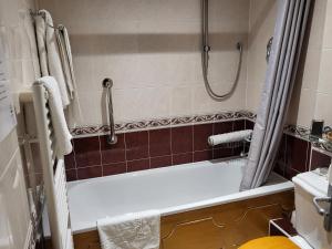 a bath tub sitting next to a toilet in a bathroom at The Royal Inn in St Austell