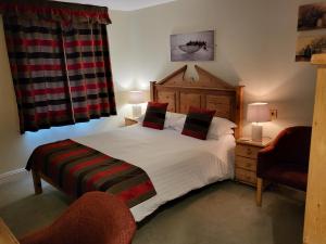 a bedroom with a large bed and a chair at The Royal Inn in St Austell
