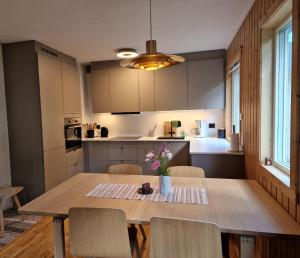 a kitchen and dining room with a wooden table and chairs at Slettvold Lyngen in Svensby