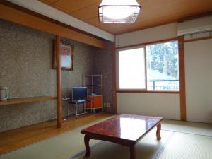 a living room with a coffee table and a window at Ryokan Miyuki in Hakuba