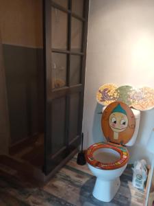 een badkamer met een toilet en een houten stoel bij Echappée sauvage in Masquières