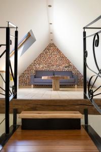 un banc dans une pièce avec un mur en briques dans l'établissement Het Spechtennest, à Zedelgem
