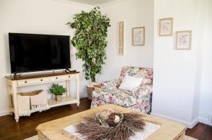 sala de estar con TV, silla y mesa en Cozy Cottage Retreat in the Heart of Utah Valley, en Orem