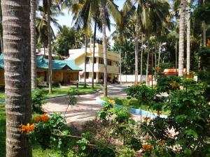 a resort with palm trees and a building at La Mirban in Varkala