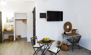 a room with a table and chairs and a tv on a wall at Callas Residence in Triánta