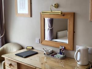 a wooden desk with a mirror on a wall at The Royal Inn in St Austell