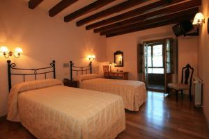 une chambre d'hôtel avec deux lits et une chaise dans l'établissement La Casona De Baró, à Baró