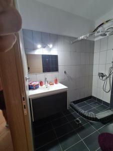 La salle de bains est pourvue d'un lavabo et d'une douche avec un miroir. dans l'établissement Village Giorgos, à Áyios Spirídhon
