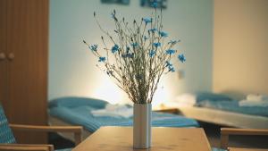 a vase with blue flowers sitting on a table at Hotel Chytrov in Volfířov