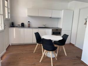 a kitchen with a table and chairs in a room at Saint-Tropez Centre - Grand Studio avec terrasse in Saint-Tropez