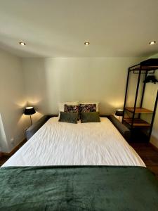 1 dormitorio con 1 cama blanca grande y 2 almohadas en Chez Naomi - Studio Mirjam, en Châtel