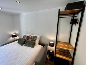 Dormitorio pequeño con cama y espejo en Chez Naomi - Studio Mirjam en Châtel